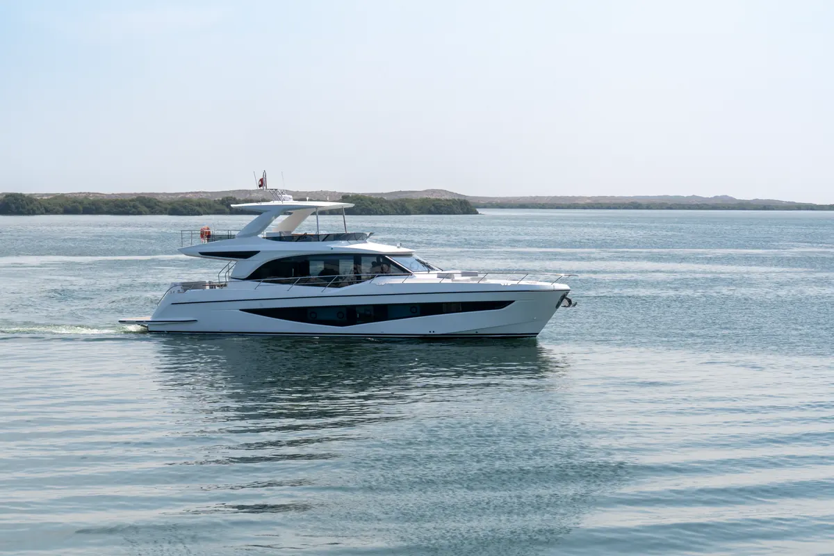 Majesty 65 cruising past a low green shoreline
